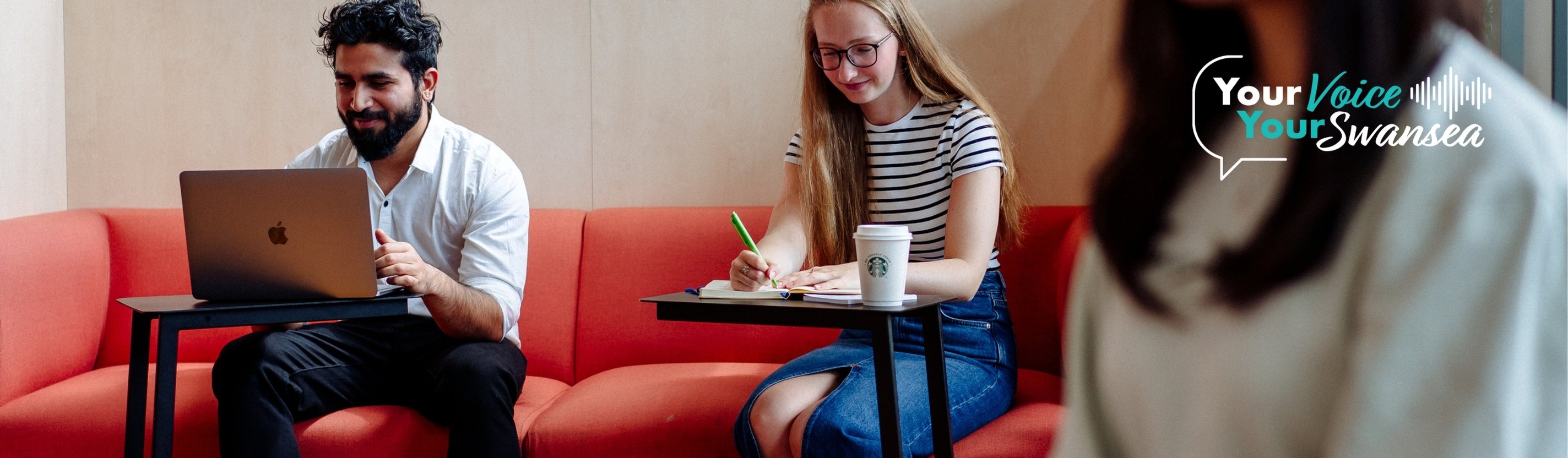 Students working on laptops and writing notes 
