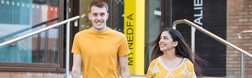 Two students in yellow leaving the Taliesin
