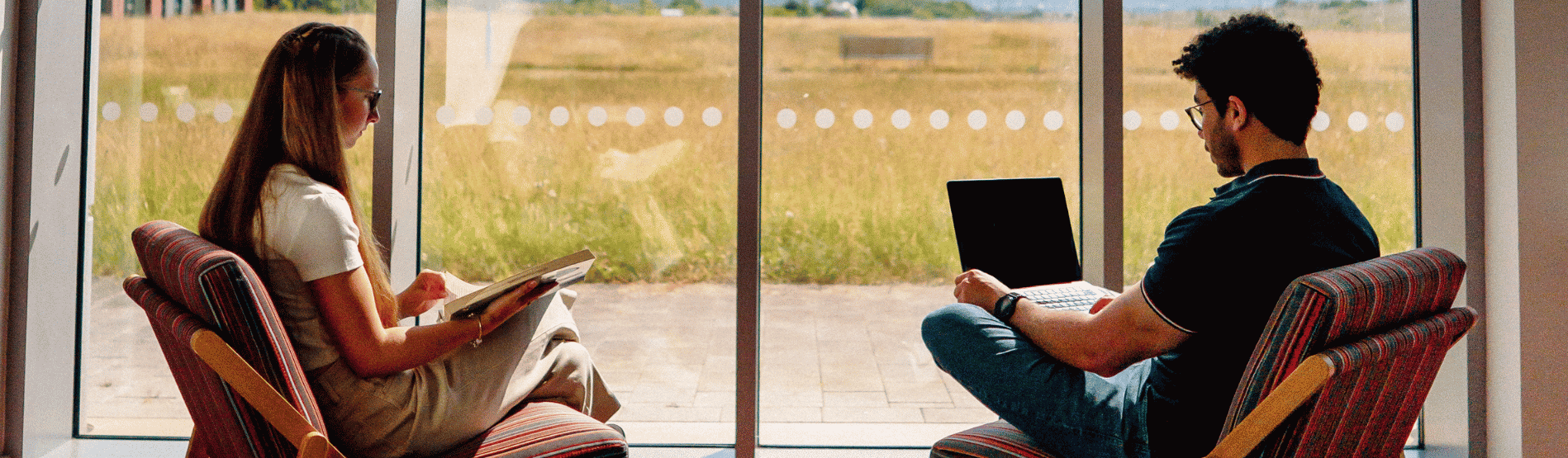 Two students talking to each other inside the Bay Campus library building