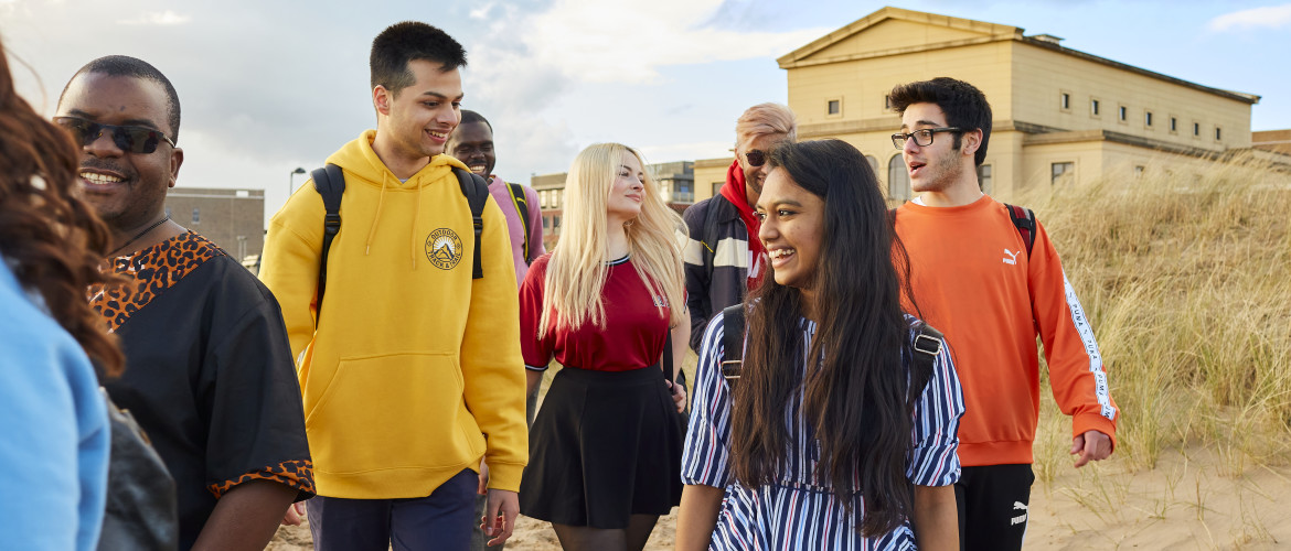 students on beach, building in background