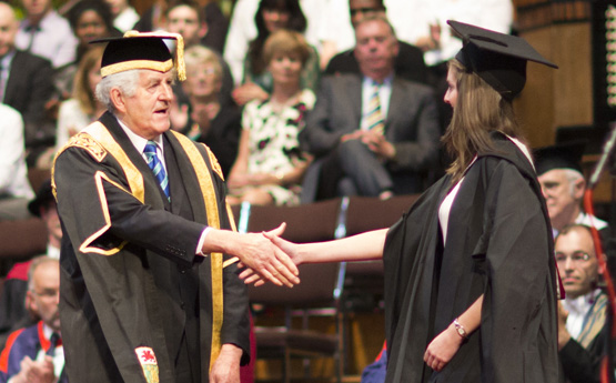 Myfyriwr yn graddio