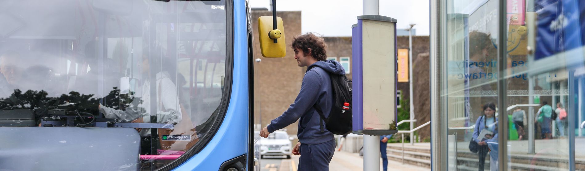 Student stepping onto a First Bus on campus 