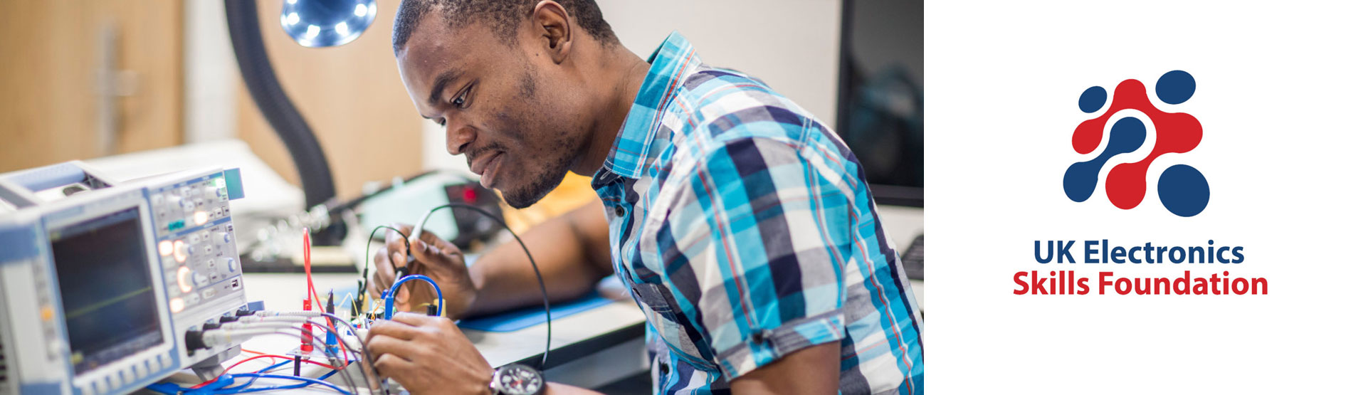 male student experimenting with a circuit board 