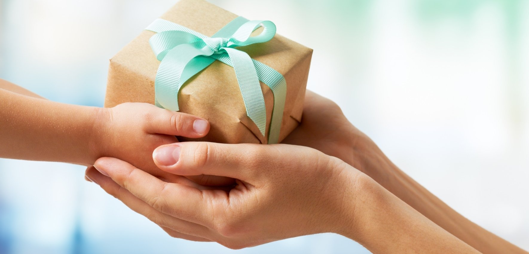 Adult hands handing a gift into a childs hands
